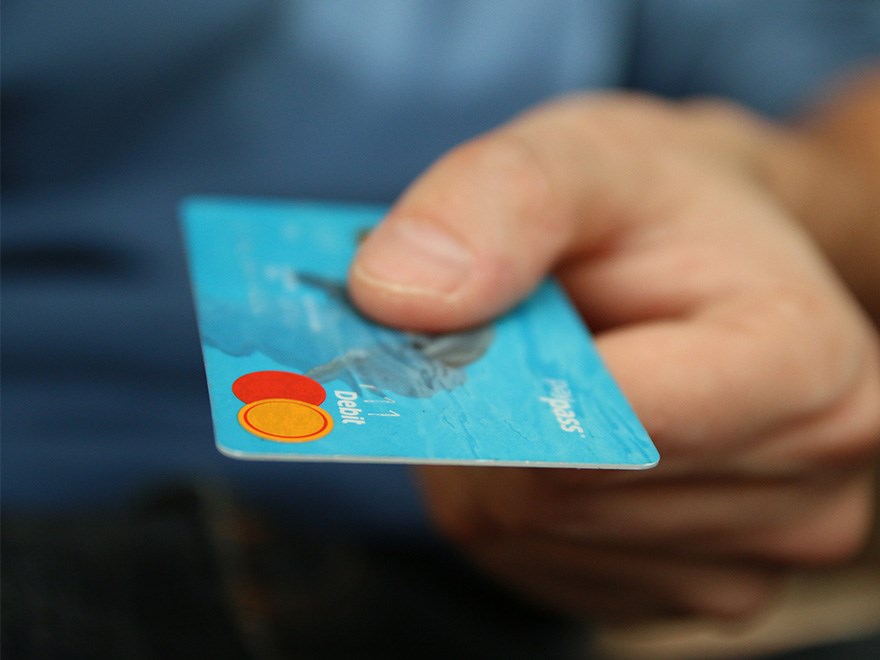 Hand som håller i ett betalkort