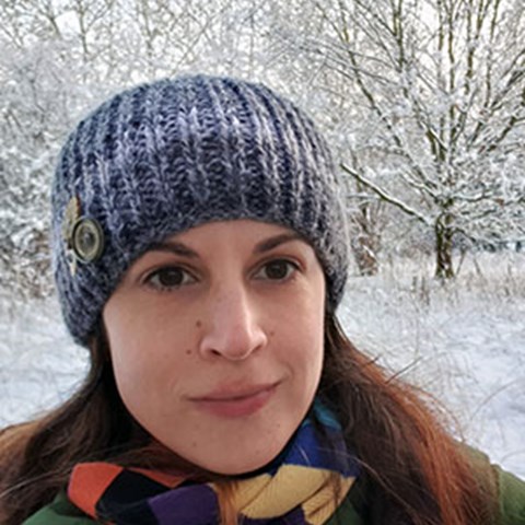 Portrait of Cat Scott in a snow covered landscape with trees in the background. Photography.