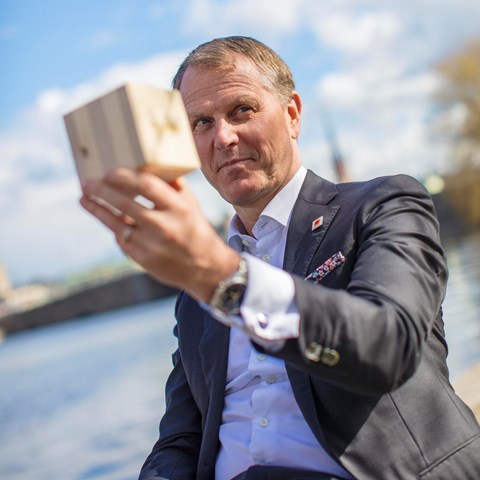 Per Lyrvall, Sverigechef på Stora Enso visar upp en kub av korslimmat trä.