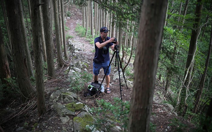 Marcus Hedblom står i en skog med en 3D-kamera.