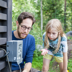 Forskare Tim Hofmeester visar medborgarforskare Hugo Asplund hur viltkameran fungerar. Foto.