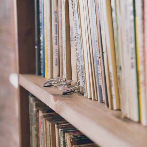 Bookshelf with a pair of glasses in front.