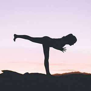 A person in a yoga pose in backlight. 