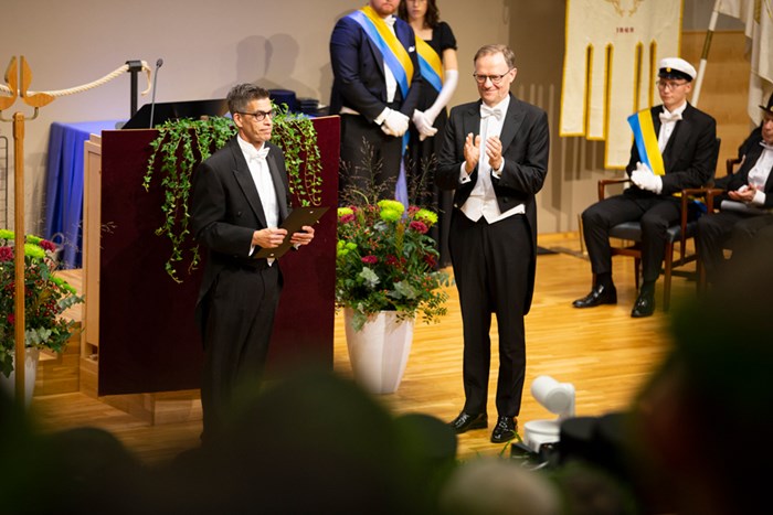 Philip McCleaf receives Vice-Chancellor Mårten Carlsson's award on stage.