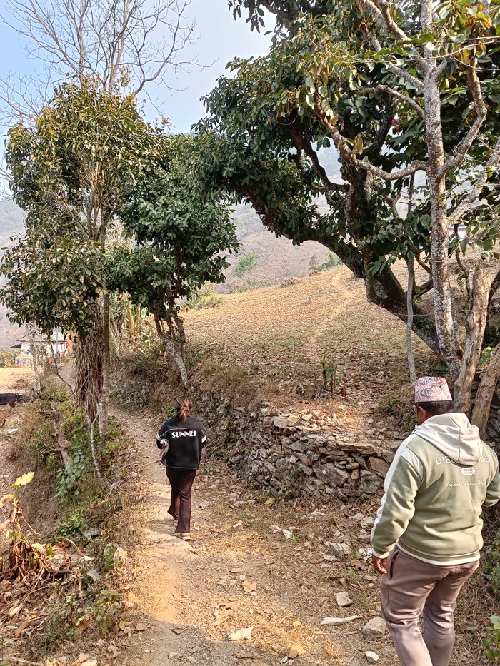 Two people with their backs to the camera walking in a rugged landscape
