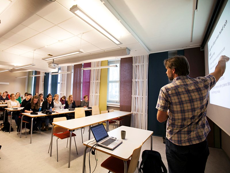 Lärare och studenter i en föreläsningssal, foto.