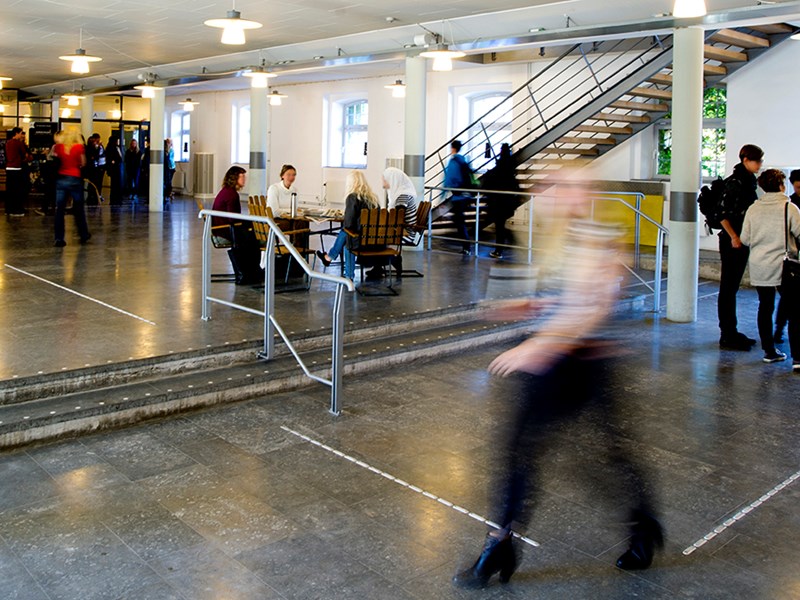 Students in motion in campus building, photo.