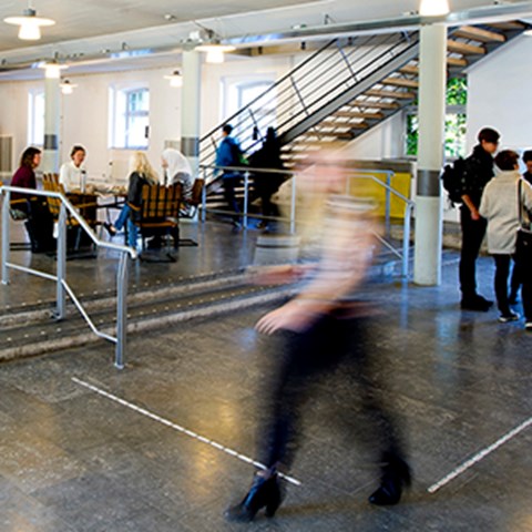 Indistinct movements of student swiftly walking through entrance hall. Photo.