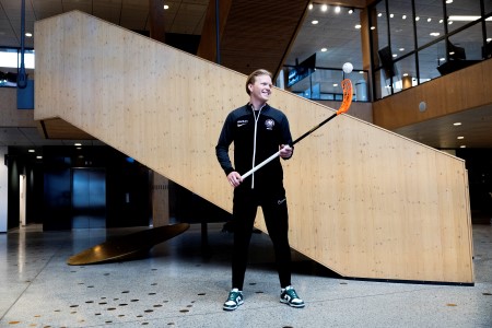 Otto står med innebandyklubba vid en trapp