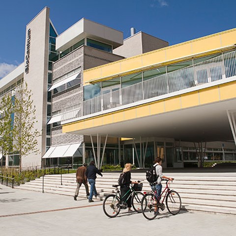 Två studenter går med sina cyklar på campus Ultuna, foto.