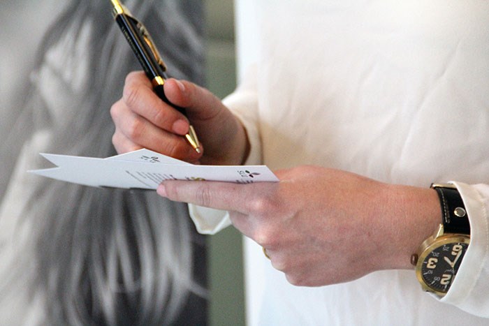 Close-up of a person holding a document and pen, photo.