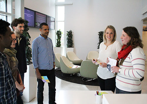 En grupp studenter står och pratar med varandra, foto.