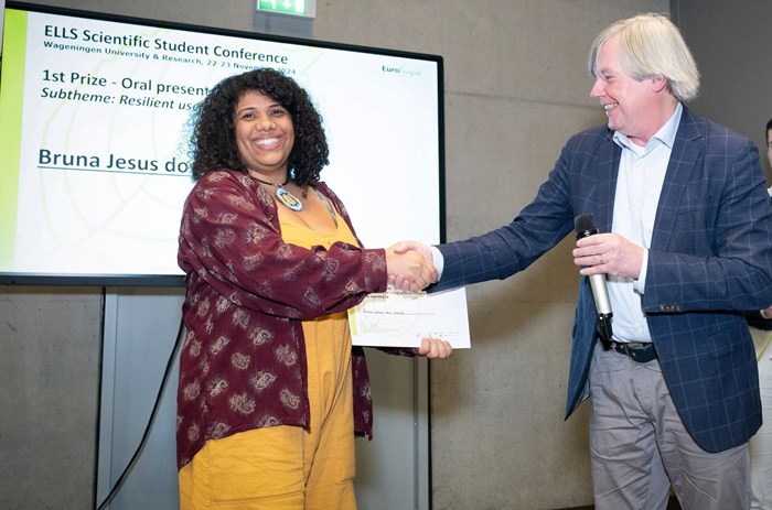 Bruna receives her award for best oral presentation from Arnold Brecht. Photo Guy Ackermanns