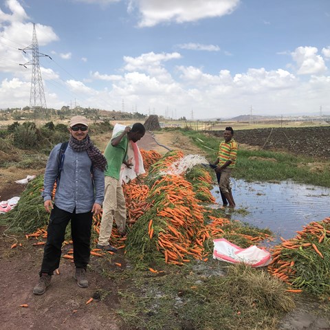 Jonathan framför ett berg av morötter i Etiopien