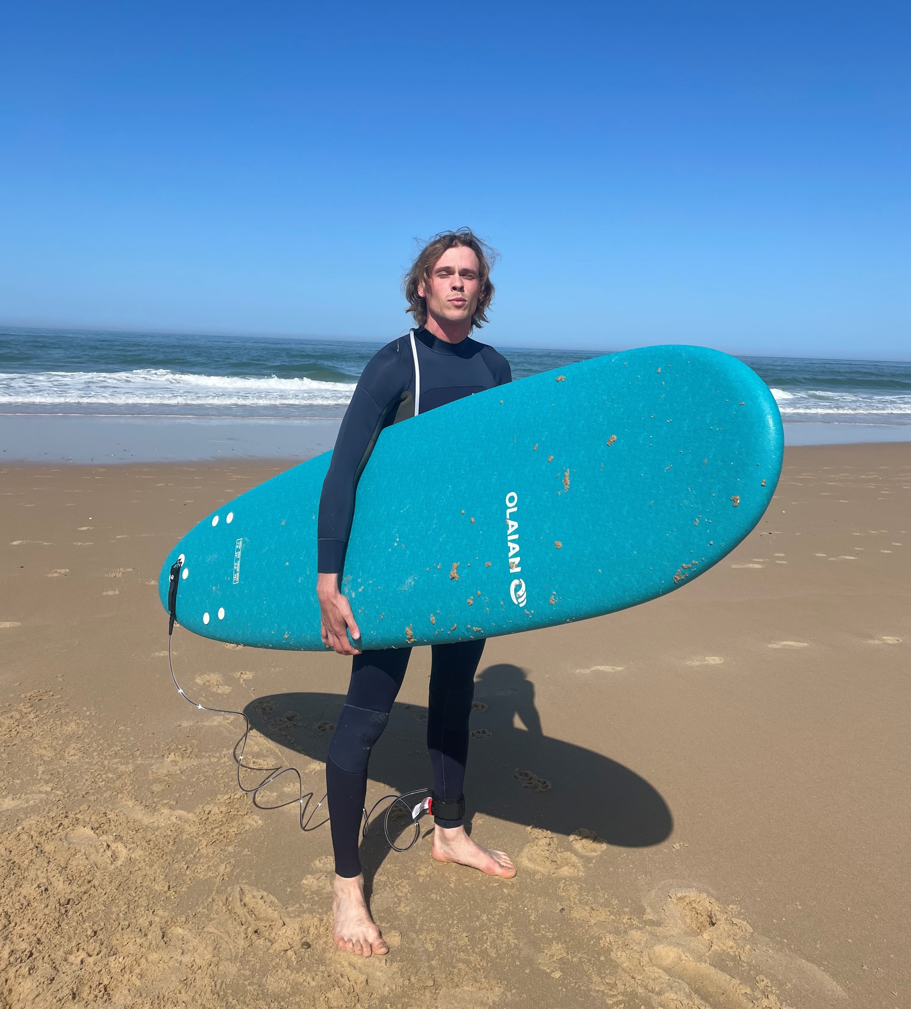 Johan with a surf board on a beach
