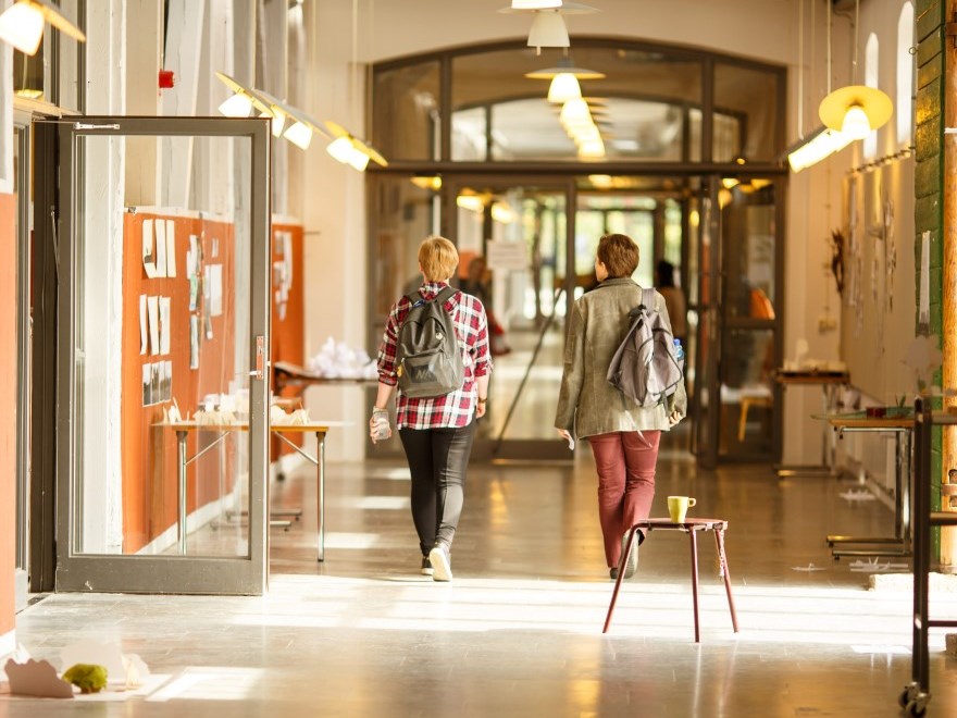 Två kvinnliga studenter går i en korridor, foto.